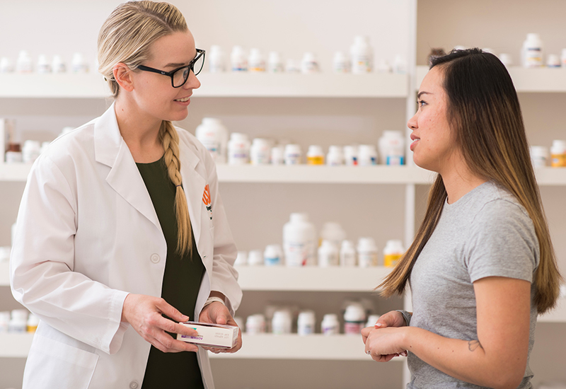 Student consulting patient in pharmacy