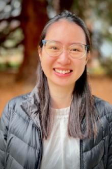 Phuong Duong Standing in front of a western cedar tree.